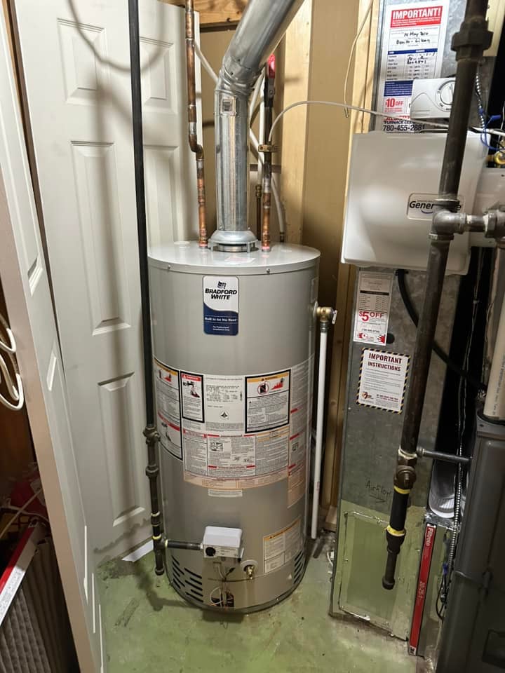 Bradford White water heater with pipes and attached ventilation pipe in a utility room.