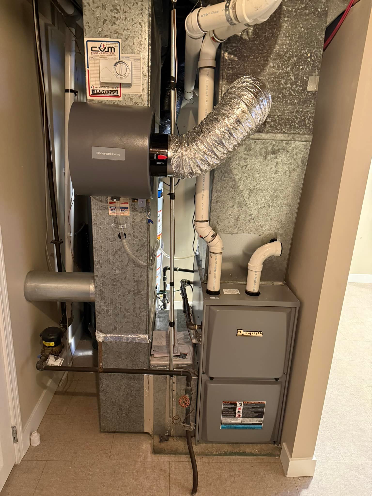 Indoor HVAC system with Honeywell Home component, ductwork, and Ducane furnace in a utility room.