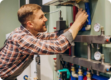plumber working on a headboard of pipes