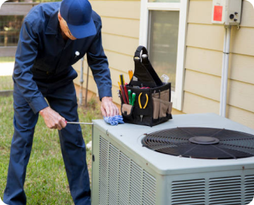 technician working on an outdoor AC unit