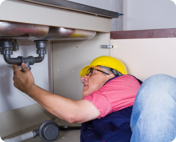 plumber working under a sink