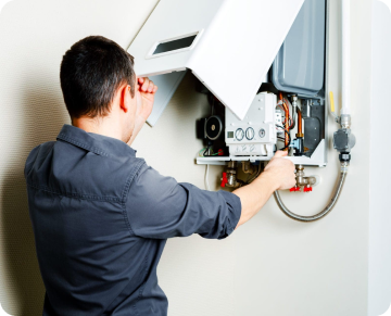 technician working on a boiler room controller unit